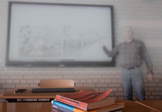 Person präsentiert etwas am Whiteboard, Teilnehmer schreiben mit